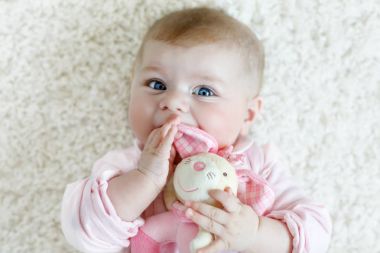 Renkli pastel, eski model çıngıraklı yılanla oynayan tatlı bir kız.