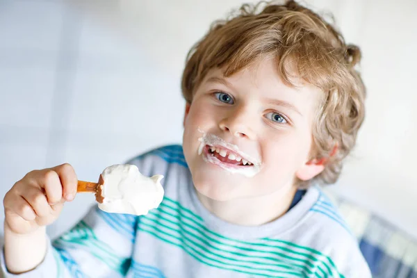 食べる巻き毛の金髪の小さな子供少年アイス チョコレート自宅でクリーム、アイス キャンデー — ストック写真