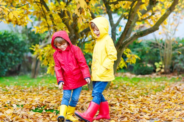 Due piccoli migliori amici e bambini ragazzi autunno parco in vestiti colorati . — Foto Stock