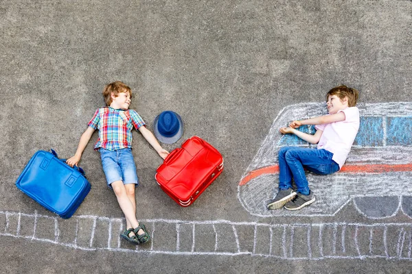 Two little kids boys having fun with train picture drawing with colorful chalks on ground — Stock Photo, Image