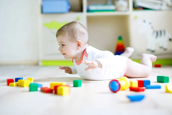 Schattige babymeisje spelen met kleurrijke houten blokken — Stockfoto