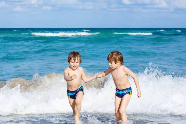 Dos niños corriendo en la playa del océano en Florida — Foto de Stock