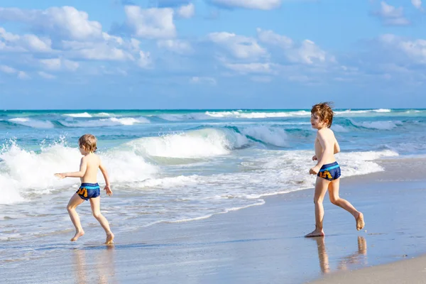 Dos niños corriendo en la playa del océano en Florida — Foto de Stock