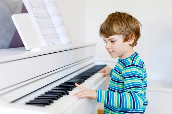 Hermoso niño pequeño tocando el piano en la sala de estar o la escuela de música — Foto de Stock