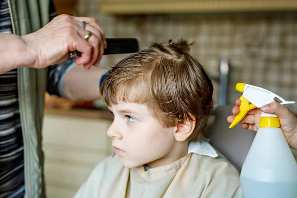 Vacker liten pojke med blont hår att få sin första frisyr. — Stockfoto