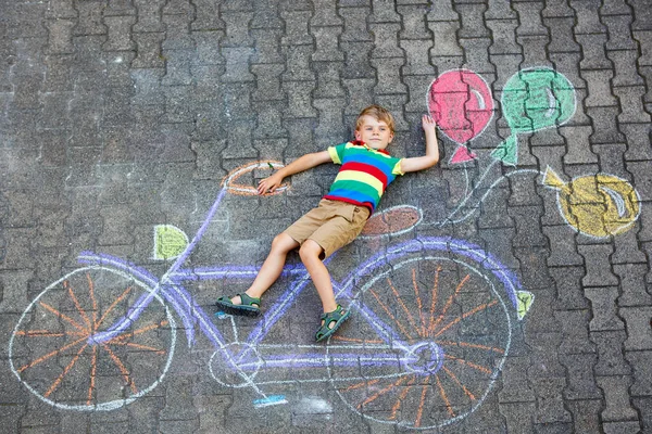 Liten unge pojke att ha kul med cykel kritar bilden på marken — Stockfoto