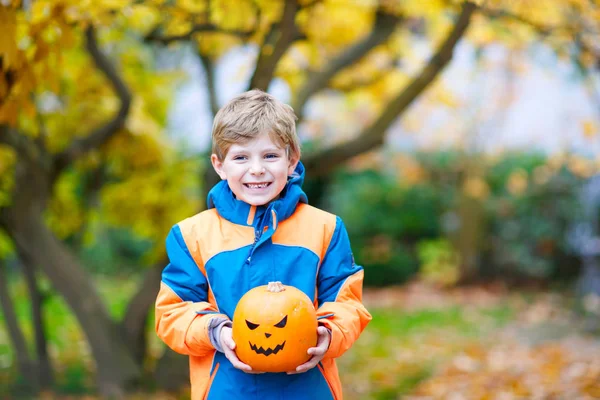 Happy cute little kid boy with halloween pumpkin lantern on autumn — Stock Photo, Image