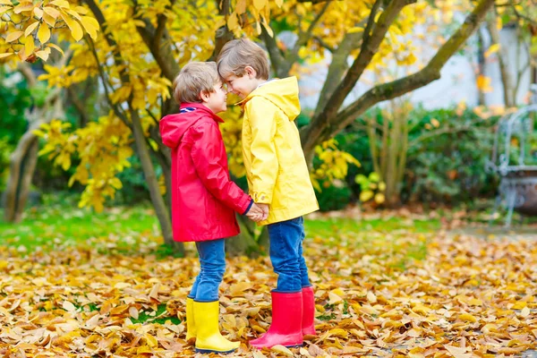 Twee kleine beste vrienden en kids jongens herfst park in kleurrijke kleding. — Stockfoto