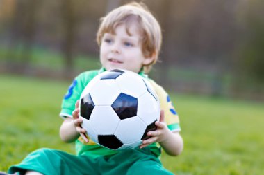Küçük şirin çocuk çocuk futbol futbol sahasında açık havada oynamak 4