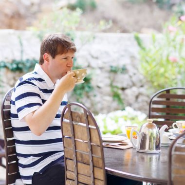 genç adam çeşitli sıkışmaları ile yaz aylarında dışarıda Kahvaltı,