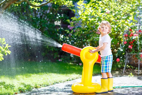 Petit garçon enfant jouer avec un arroseur d'eau tuyau d'arrosage — Photo