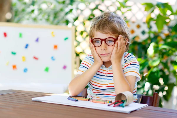 Okul donanımları tutan gözlüklü küçük çocuk çocuk — Stok fotoğraf