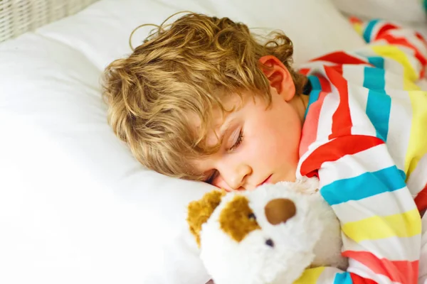 Pequeño niño rubio en ropa de dormir colorida — Foto de Stock