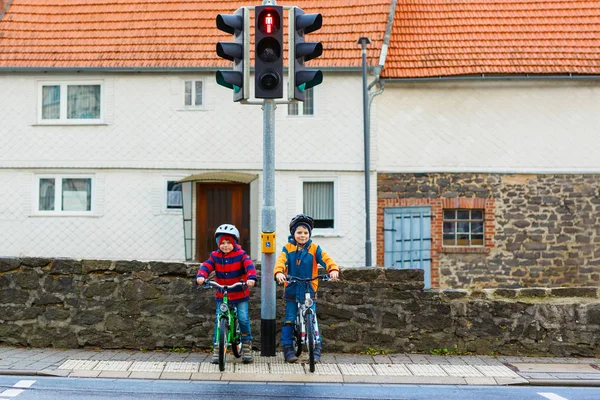 Two kids boys biking and waiting on traffic light — Stock Photo, Image