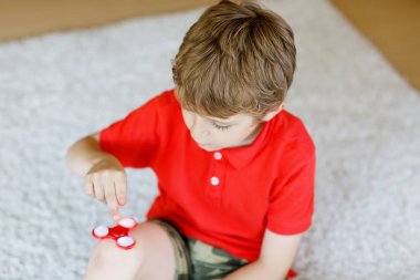 Tri kıpır el Spinner ile kapalı oynayan okul çocuk
