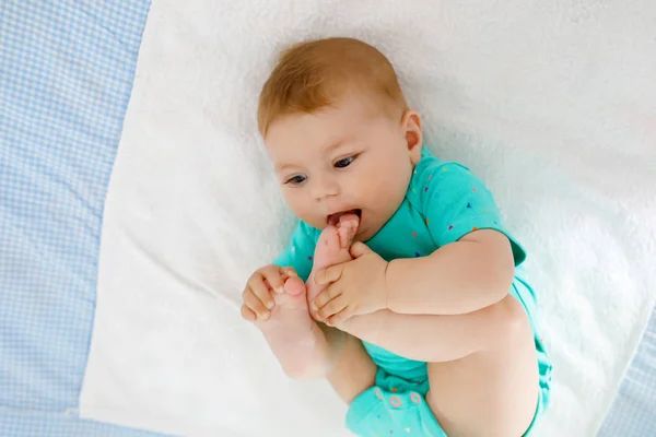 Bebê bonito tomando pés na boca. Adorável pequena menina chupando pé . — Fotografia de Stock