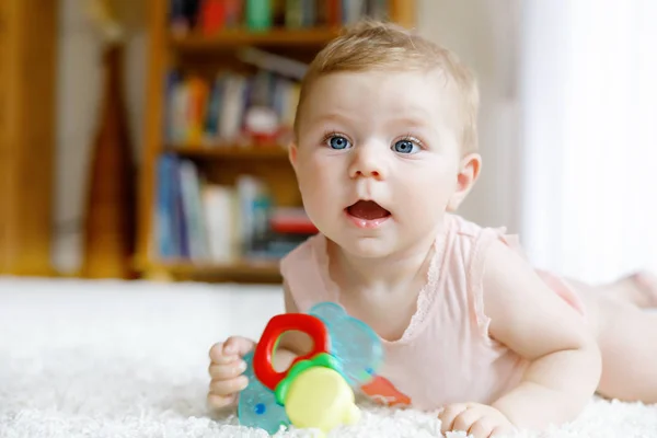 Bonito bebê menina brincando com brinquedos chocalho colorido — Fotografia de Stock