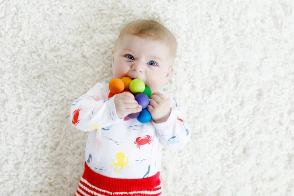 Bonito bebê menina brincando com colorido brinquedo chocalho de madeira — Fotografia de Stock