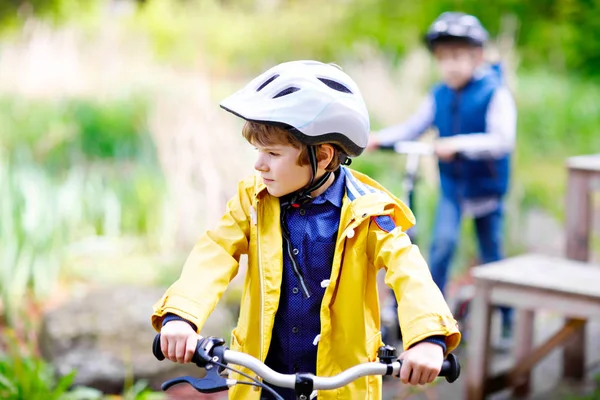 Two little kids boys driving and running on bicycles in park — Stock Photo, Image