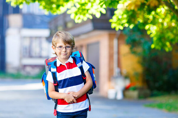 little kid boy with school satchel on first day to school