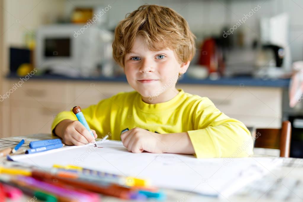 Tired kid boy at home making homework writing letters with colorful pens