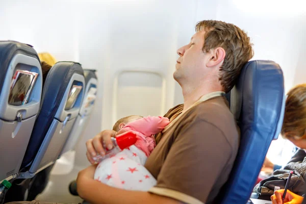 พ่อหนุ่มที่เหนื่อยล้าและลูกสาวของเขานอนหลับระหว่างการบินบนเครื่องบินในวันหยุด — ภาพถ่ายสต็อก