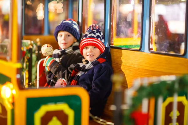 Два маленьких мальчика на карусели на Рождественской ярмарке — стоковое фото
