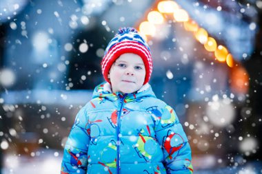 Mutlu çocuk kışın karla eğleniyor.