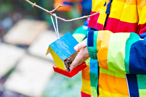 Piccolo bambino appeso casa uccello sull'albero per l'alimentazione in inverno — Foto Stock