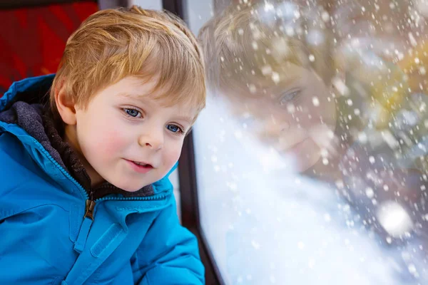 Niedliches kleines Kleinkind, das aus dem Zugfenster schaut — Stockfoto