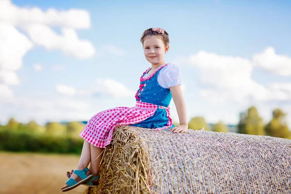 Menina bonito miúdo em traje tradicional bávaro no campo de trigo — Fotografia de Stock