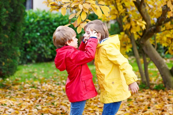 Two little best friends and kids boys autumn park in colorful cl — Stock Photo, Image