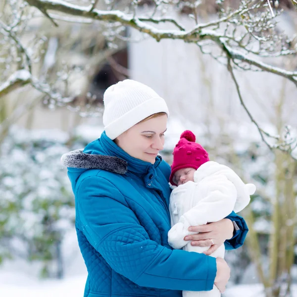 Mother holding newborn baby girl on arm outdoors — Stock Photo, Image