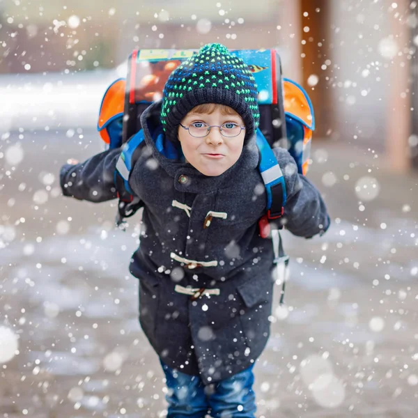 Gelukkig kid jongen hebben plezier met sneeuw op weg naar school — Stockfoto