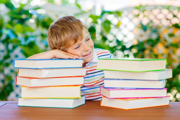 Маленький мальчик читает книги в школе — стоковое фото