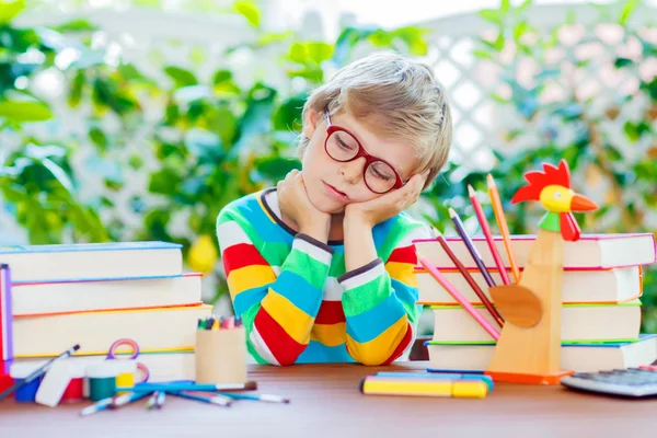 Menino da escola triste com óculos e material estudantil — Fotografia de Stock