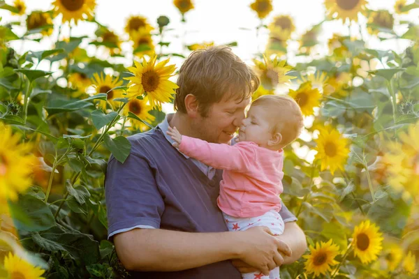 Felice orgoglioso giovane padre con figlia bambino carino nel campo di girasole, ritratto di famiglia insieme — Foto Stock