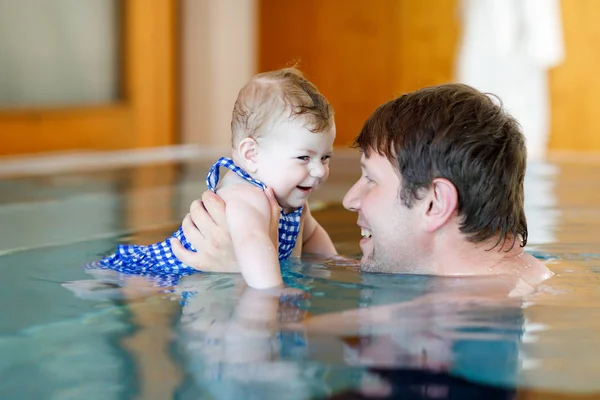 Feliz padre de mediana edad nadando con linda niña adorable en la piscina. — Foto de Stock