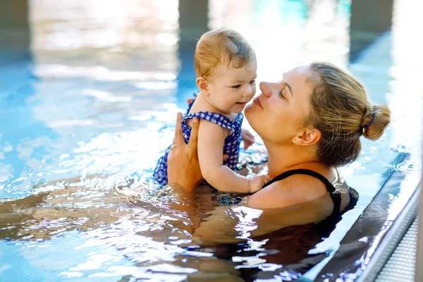 Mãe feliz nadando com bonito adorável bebê menina filha na piscina . — Fotografia de Stock
