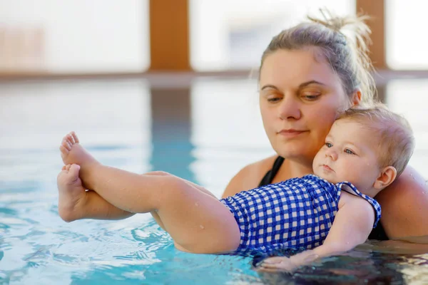 Happy mother swimming with cute adorable baby girl daughter in swimming pool. — Stock Photo, Image