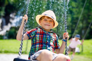 Açık sahada yağmur sırasında eğlenmek zinciri salıncak ile komik çocuk çocuk