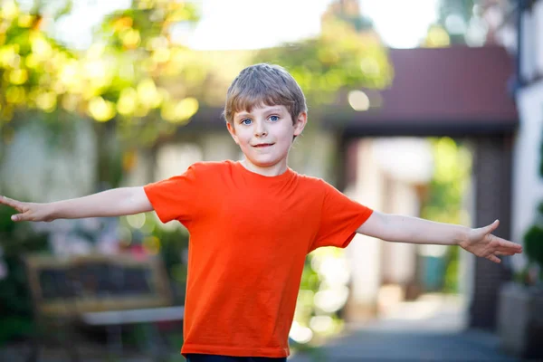 Kleiner blonder lustiger Junge läuft bei Wettkampf über Ziellinie. — Stockfoto