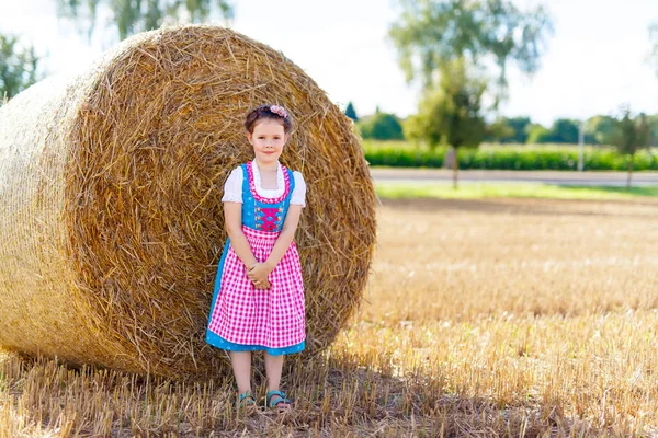 Roztomilá holčička v tradičním bavorském kostýmu v pšeničném poli — Stock fotografie