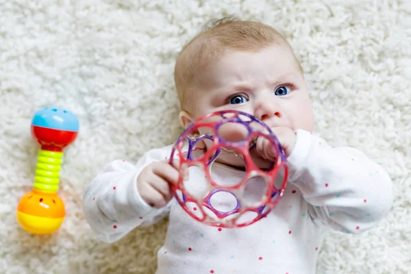 Cute baby girl playing with colorful rattle toy — Stock Photo, Image