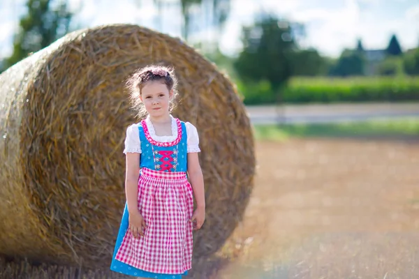 Roztomilá holčička v tradičním bavorském kostýmu v pšeničném poli — Stock fotografie