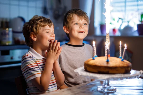 Little kid boys twins celebrating birthday and blowing candles on cake — Stock Photo, Image
