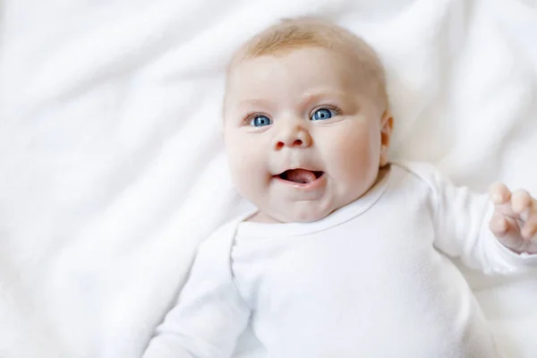 Meisje van de baby dragen witte handdoek of winter overal in witte zonnige slaapkamer — Stockfoto