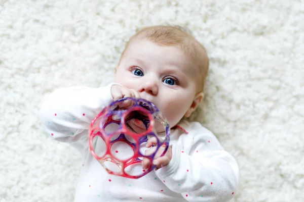 Söt liten flicka leker med färgglada skallra leksak — Stockfoto