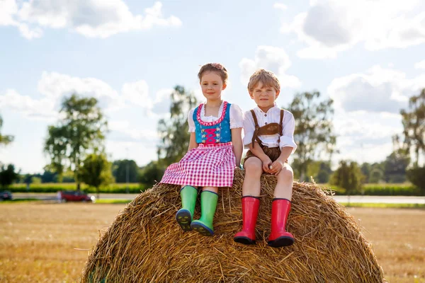 Deux enfants, garçon et fille en costumes bavarois traditionnels dans le champ de blé — Photo