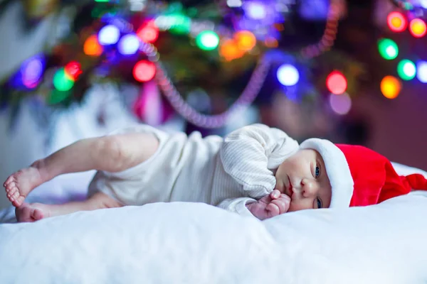 クリスマス ツリーの近くサンタ帽子で 1 週前の生まれたばかりの赤ちゃん — ストック写真